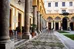The main patio of the University of Palermo with marble columns and lawns.