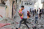 A young man walking amongst rubble in Gaza, Palestine.