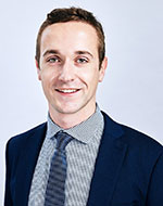 Jonathan Slagter. He is wearing a black jacked, checkered shirt and a grey tie.