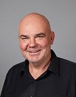 Professor Wayne Morrison smiling, wearing a black shirt.