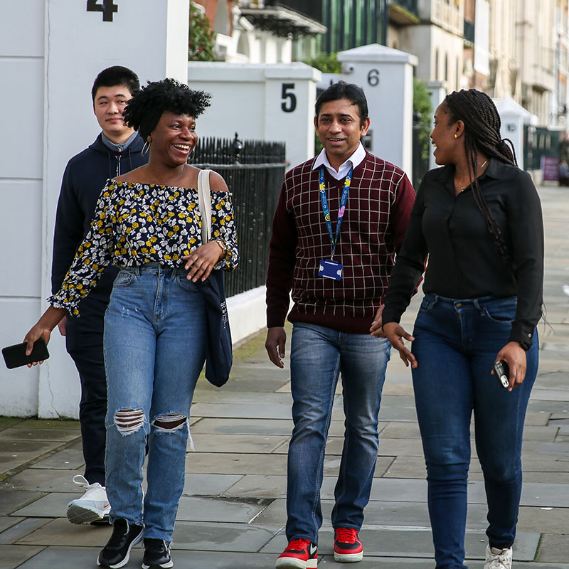Queen Mary CCLS students walking around the streets of Lincoln's Inn Fields laughing and smiling.