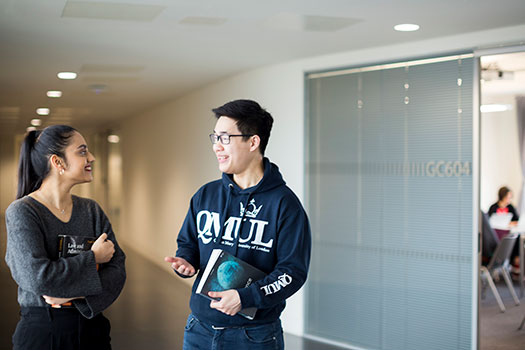 Two Queen Mary Students chatting in a corridor