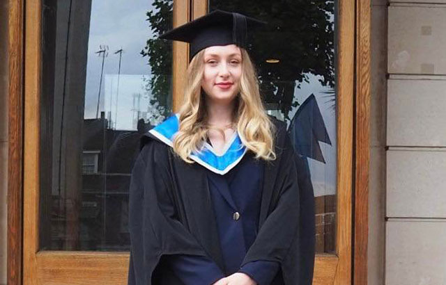 Matilda McDermott-Krasker at graduation. She is wearing a mortar board and graduation gown.