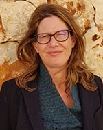 Amber Marks in glasses standing against a beige background