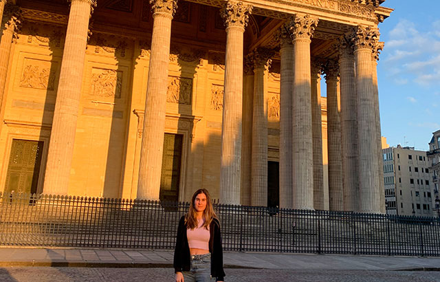 A student standing in front of the Sorbonne