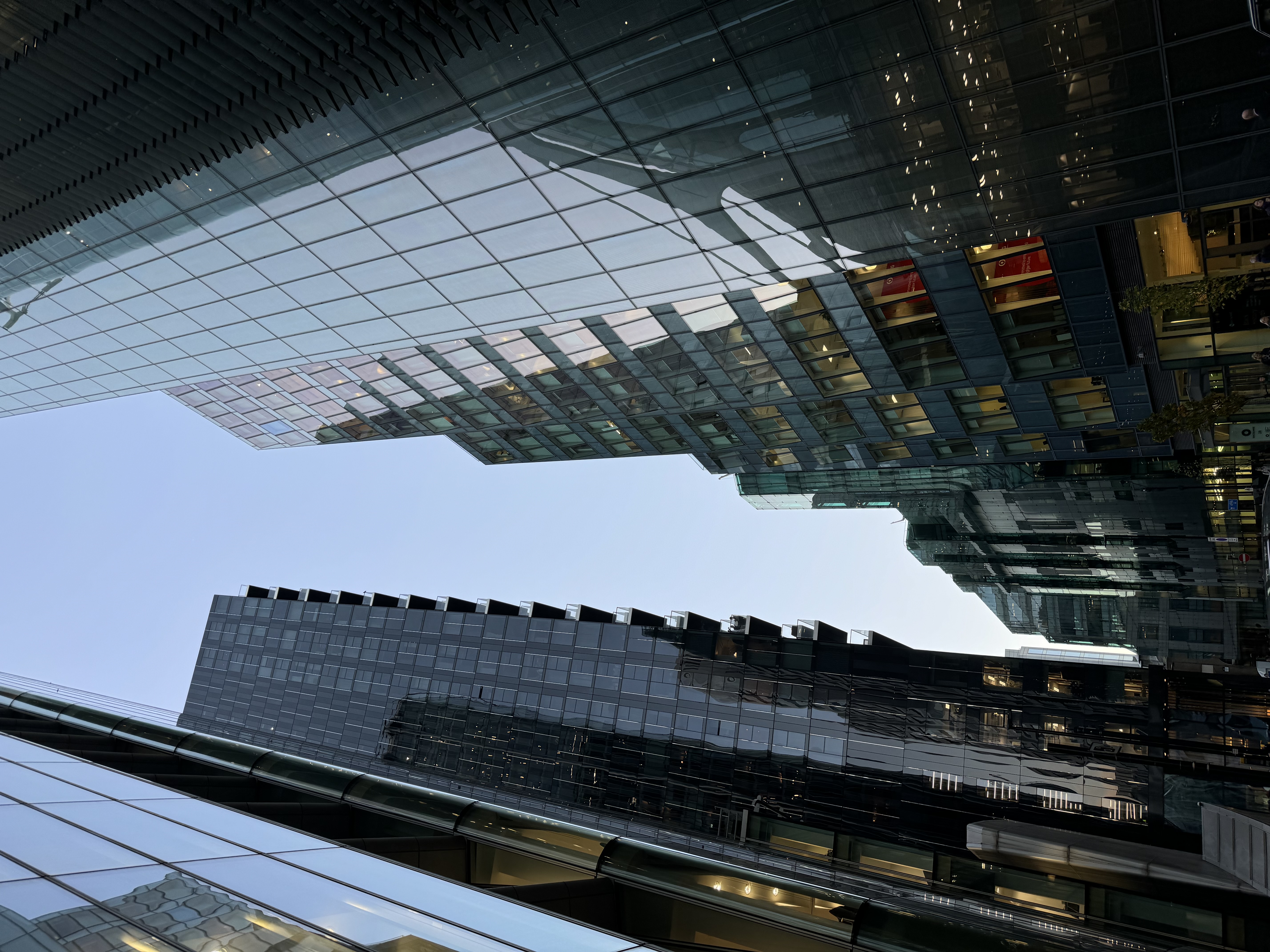 Looking up at high-rise glass buildings from the street.