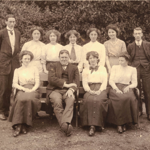 Group of ten students, two male and eight women, and Hilaire Belloc posed for a class photograph