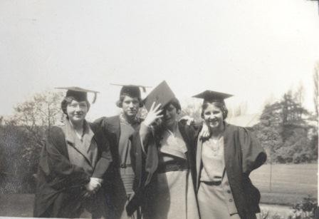 Photograph of four women graduating from Westfield College in 1931, they are dressed in caps and gowns and are smiling for the camera
