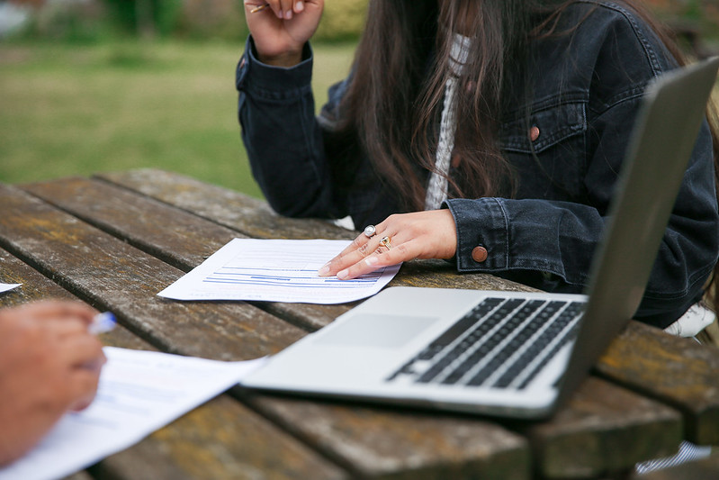 A student studying on a laptop on a bench