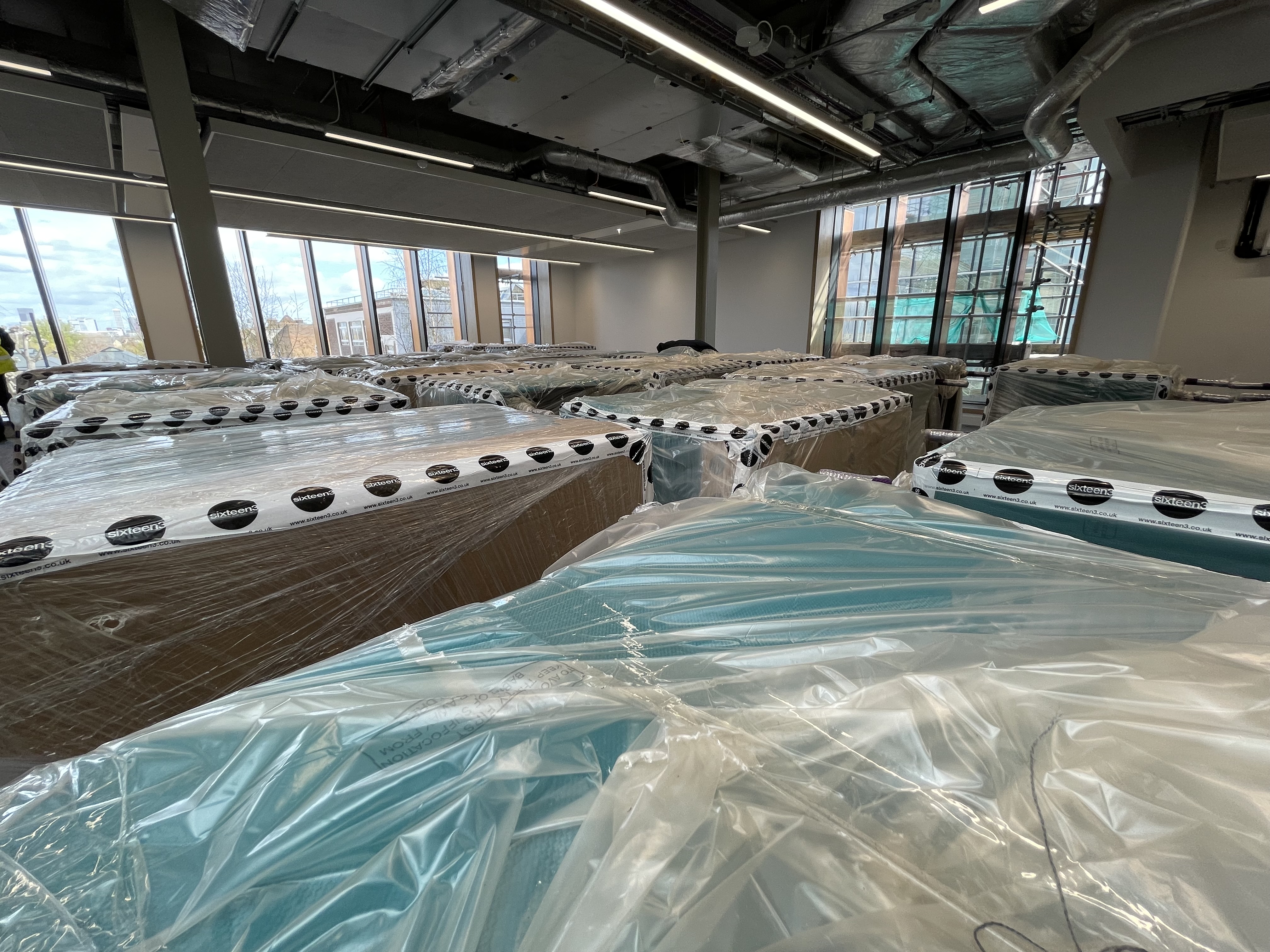 green seating covered in packing plastic and cardboard