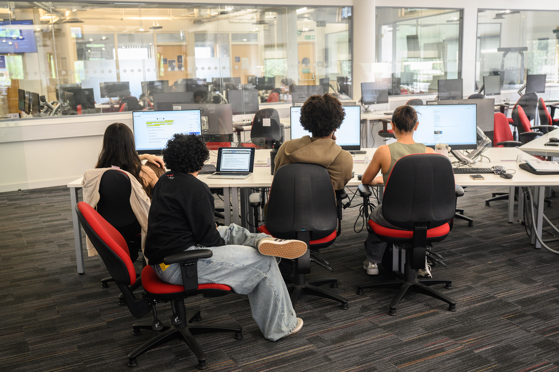 Group of 4 students working together on PC desks