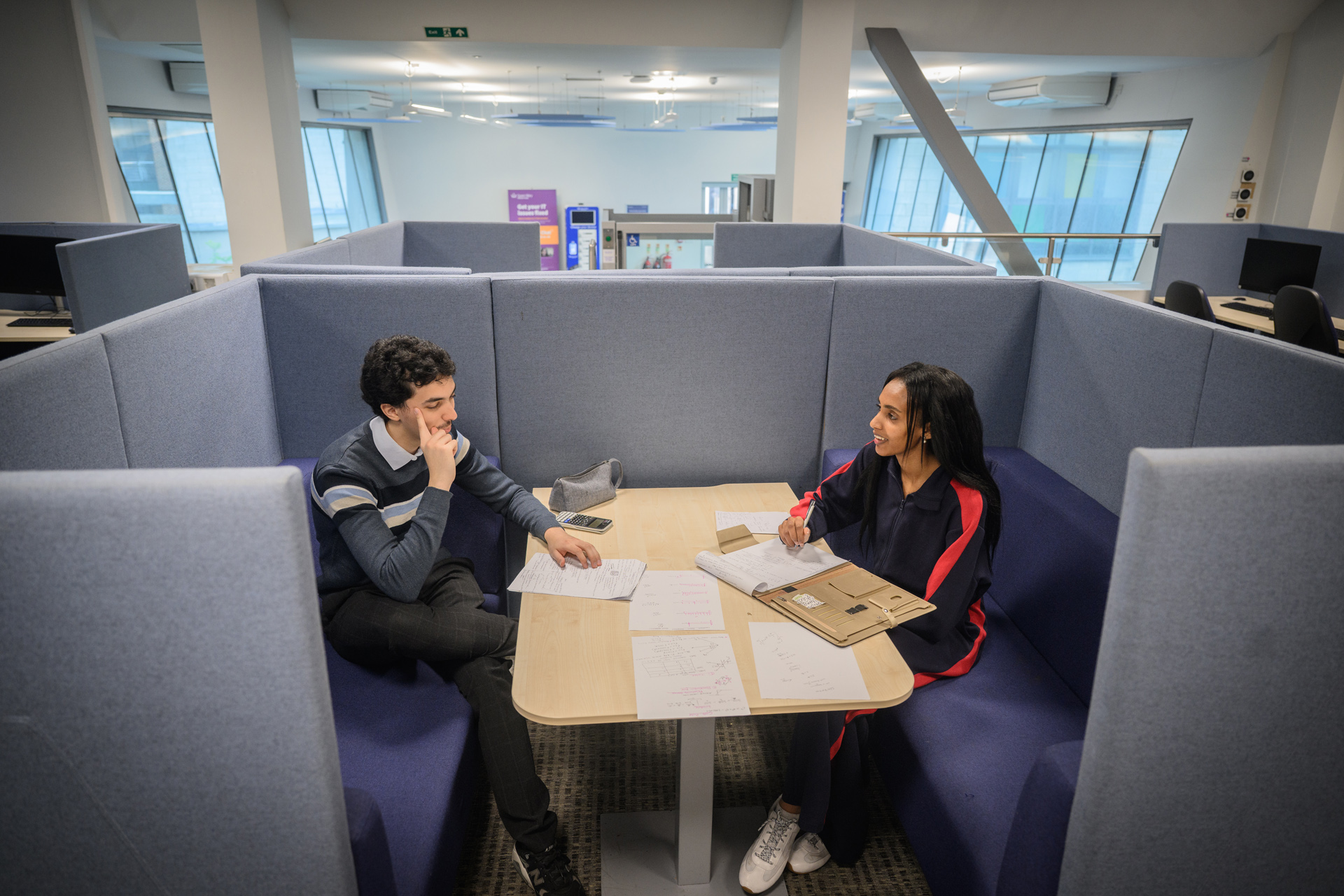 Two students working together in a group study booth