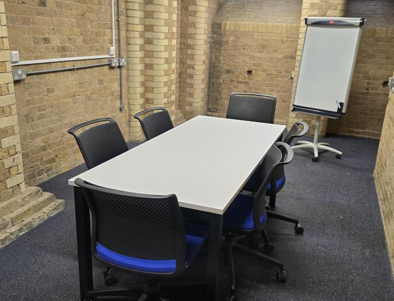 Study desk and chairs in group study room with whiteboard in the background