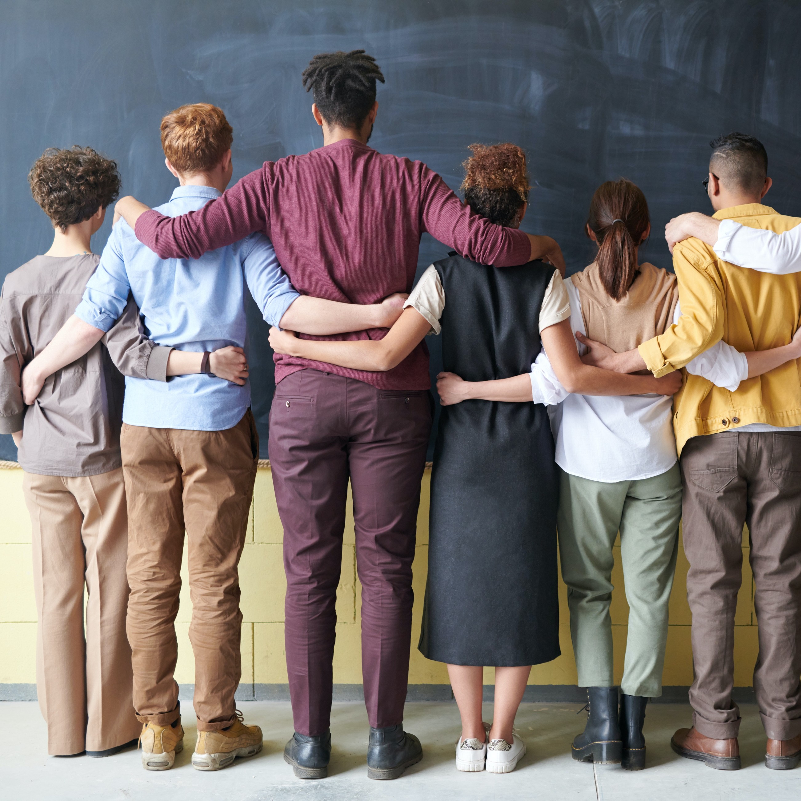 Group of teachers facing a blackboard with their backs to the camera