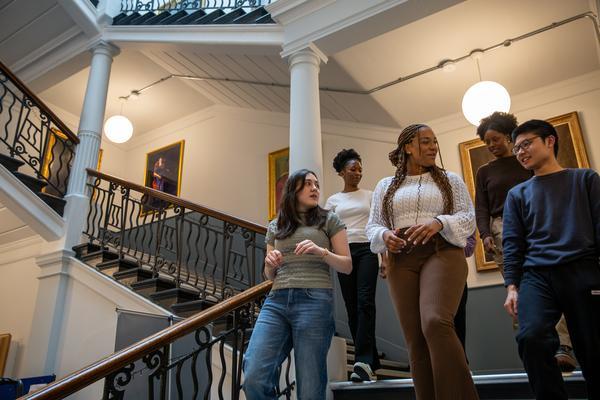 Students walking down staircase while talking to each other