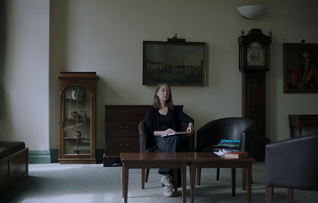 A still of the installation showing Professor Fay Dowker in the SCR at Queen Mary