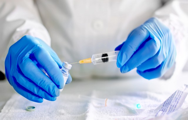 Stock image of a doctor filling an injection syringe with a vaccine