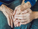A nurse holding the hand of a patient
