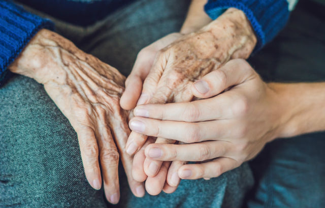 A nurse holding the hand of a patient