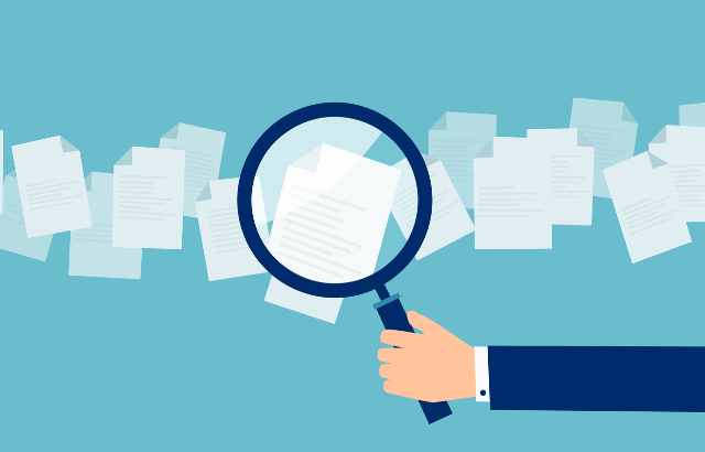 Cartoon hand with magnifying glass in front of papers. Credit: iStock.com