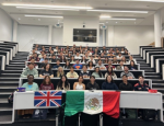 79 students sitting in rows in a lecture theatre with the Union Jack and Mexican flags on the table in front of them,