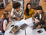 Students at work around a desk with a computer