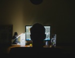 Person in dark room and computer screen