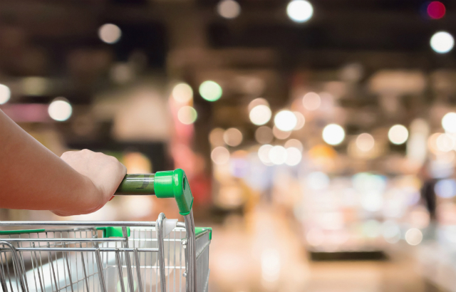 Woman with trolley shopping in a store. Credit: Kwangmoozaa/iStock.com