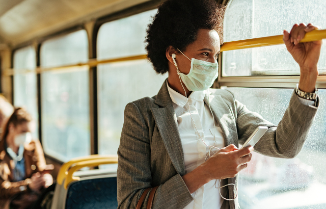 Black woman travelling by bus wearing protective face mask. Credit: Drazen Zigic/ iStock.com