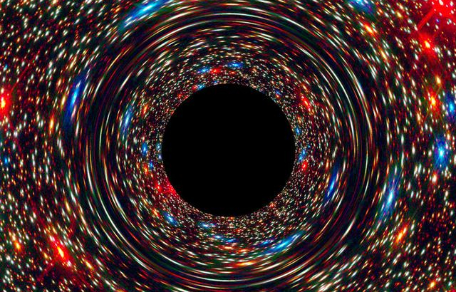 This computer-simulated image shows a supermassive black hole at the core of a galaxy. The black region in the center represents the black hole’s event horizon, where no light can escape the massive object’s gravitational grip. The black hole’s powerful gravity distorts space around it like a funhouse mirror. Light from background stars is stretched and smeared as the stars skim by the black hole. Credits: NASA, ESA, and D. Coe, J. Anderson, and R. van der Marel (STScI)
