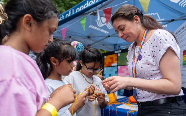 Young visitors to the Crocheting the Air stall trying out crochet