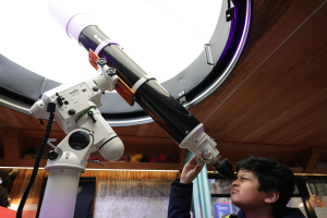 A child looks through a telescope