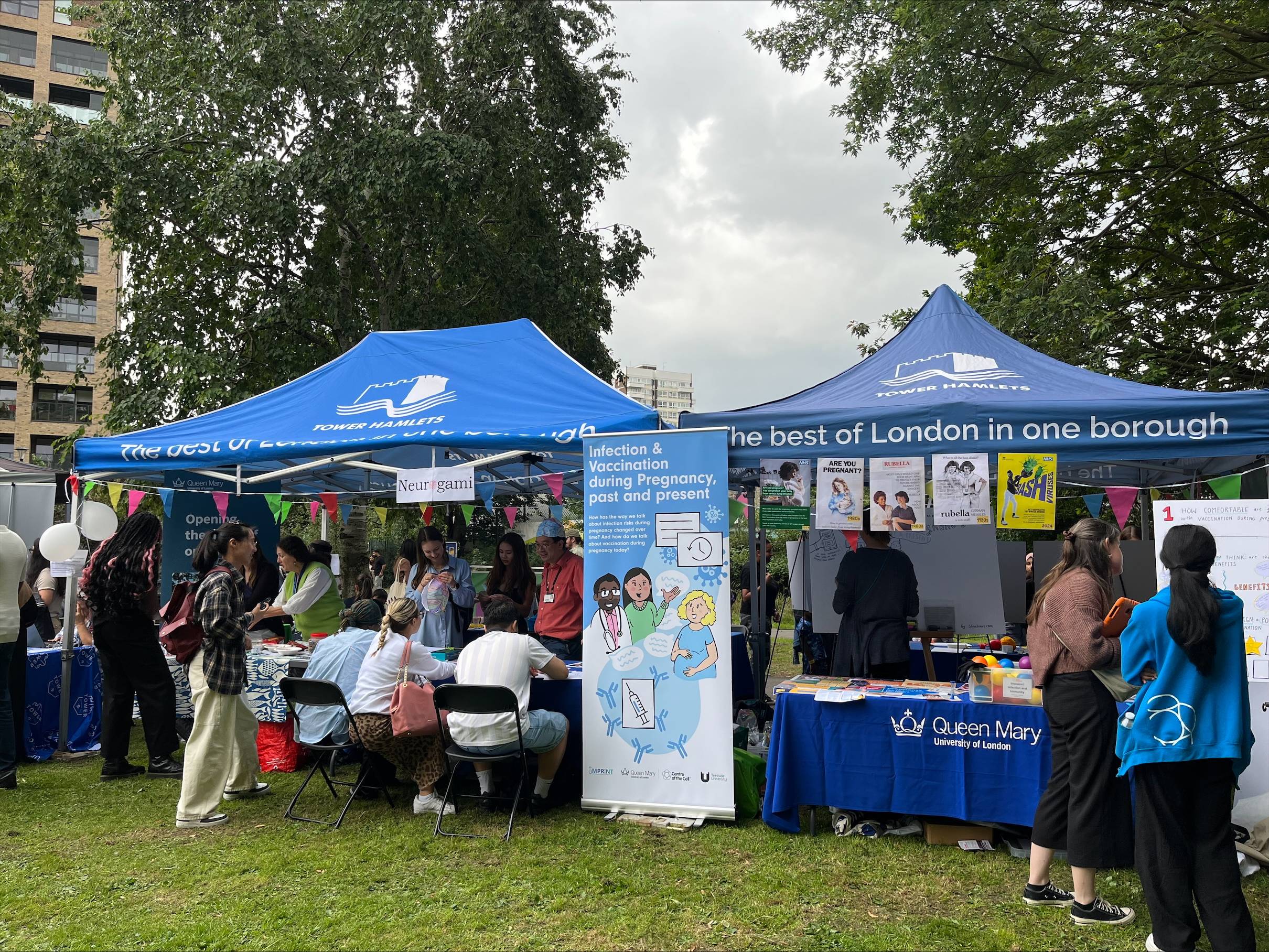 Two blue marquees with tabletop activities in a park