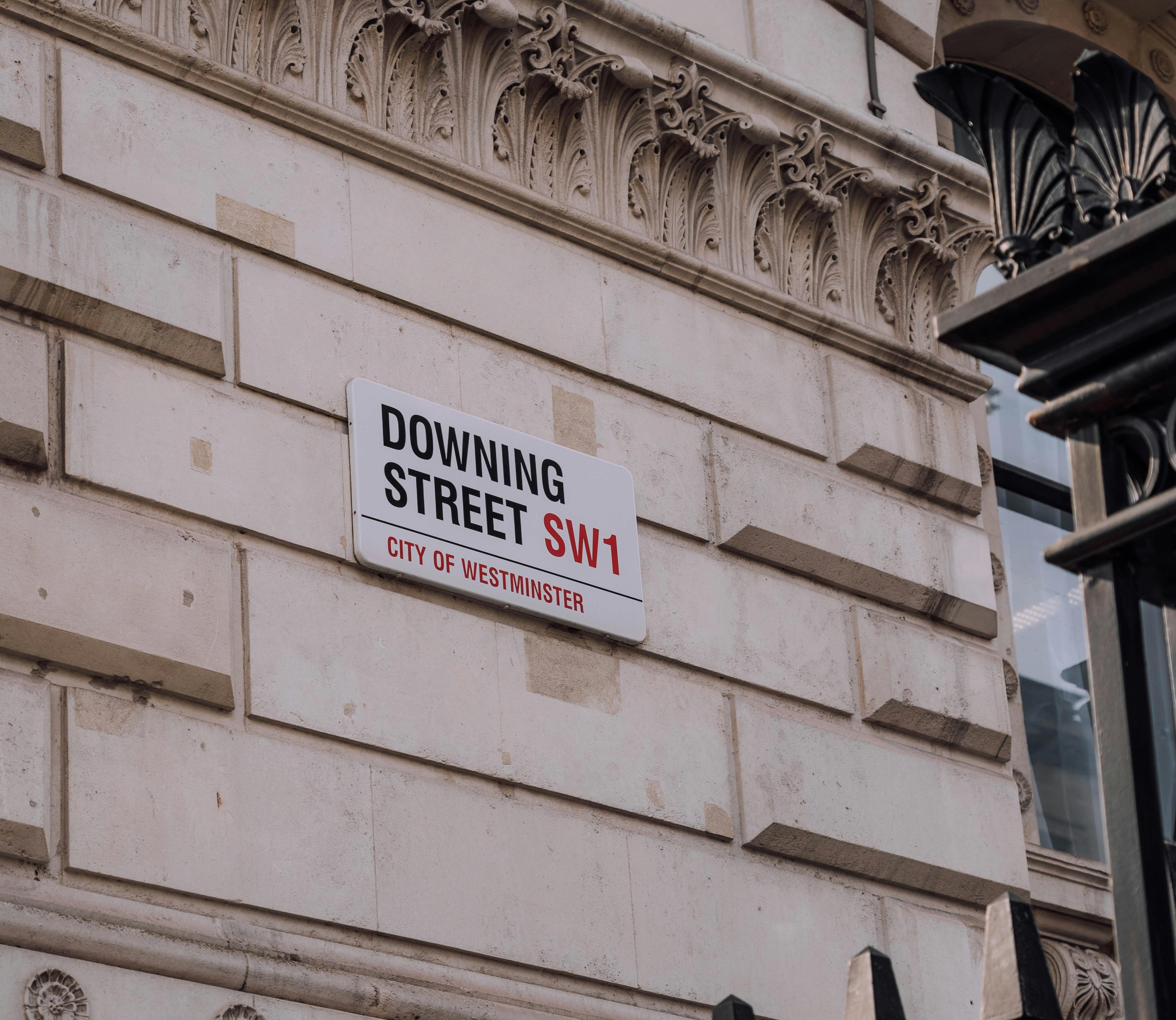 Road sign for Number 10 Downing Street on the side of the Cabinet Office on Whitehall.