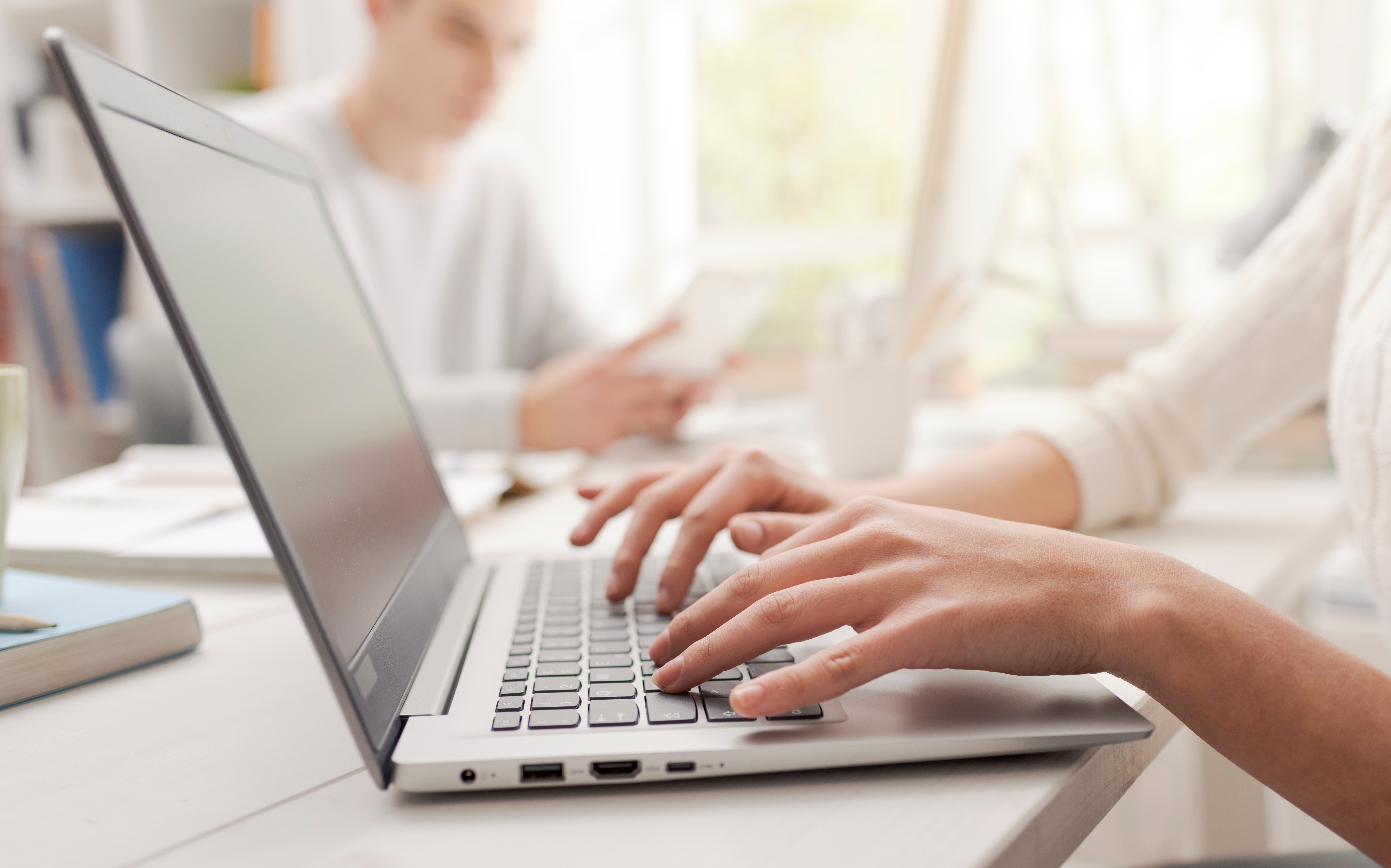 A woman typing on a laptop