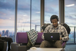 graduate student listening to headphones and looking at laptop