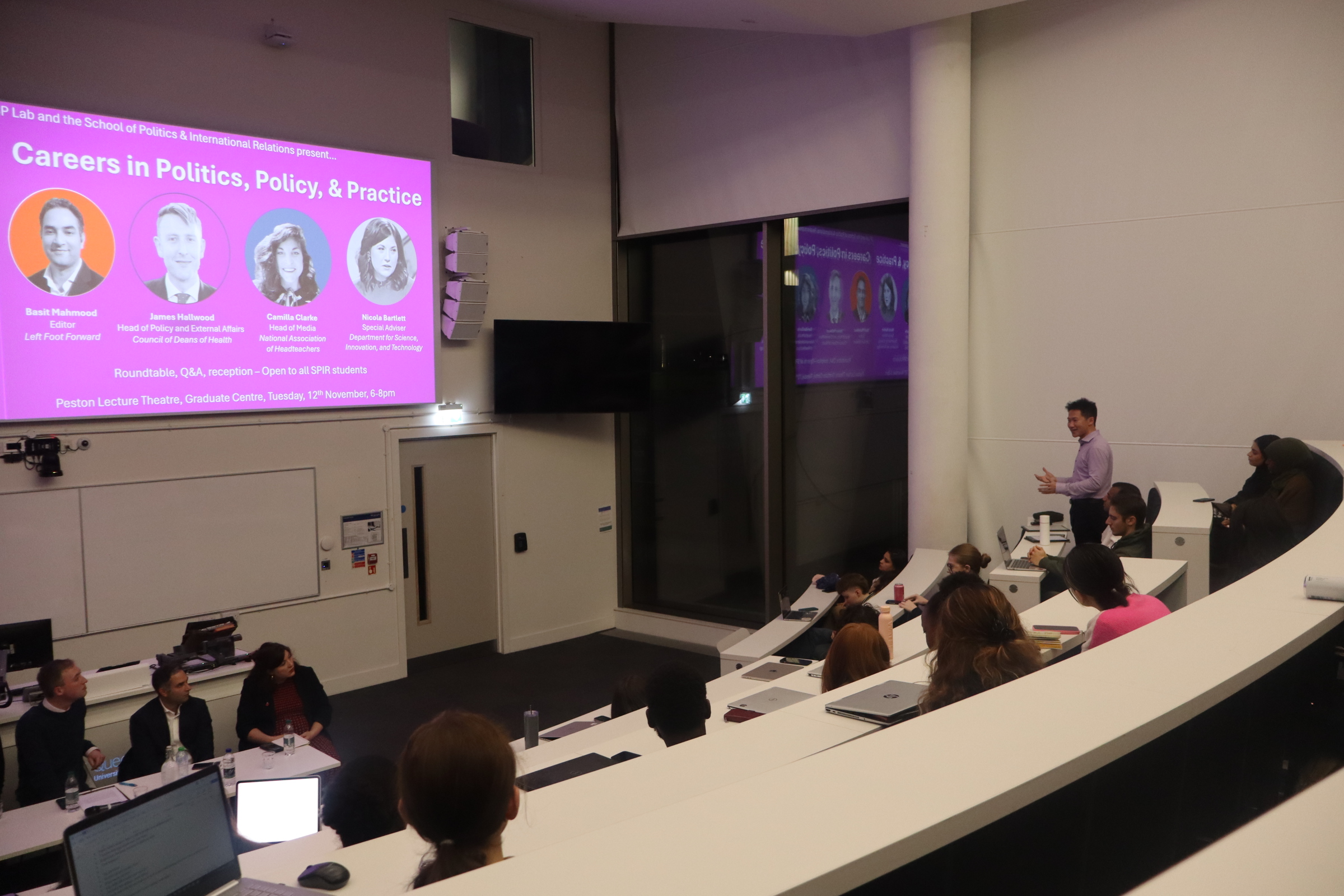 Student standing in a lecture theatre asking a question