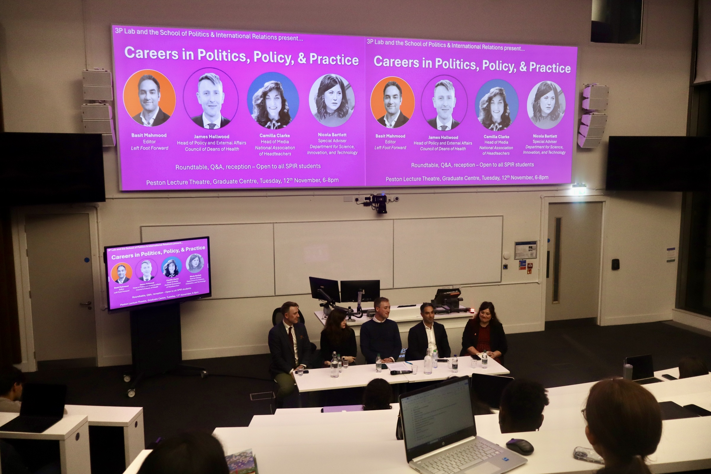 Five people sat on a panel in a lecture theatre