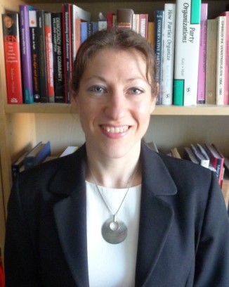A photo of Rainbow in front of a bookcase