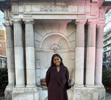 Tushitta Murali standing in front of an ornate water fountain.