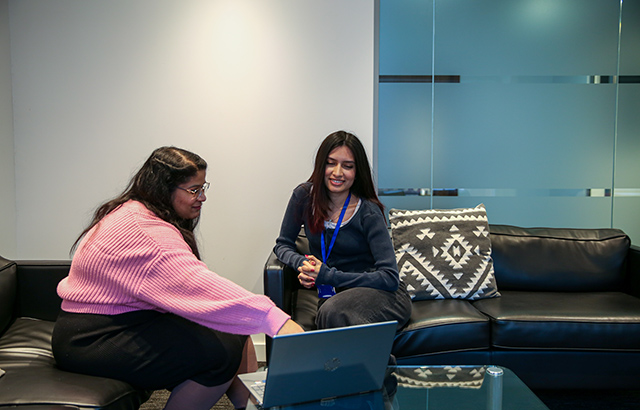 Two Centre for Commercial law Studies Students using a laptop.
