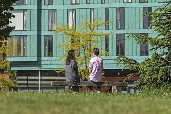 Students sitting on a bench at Mile End campus