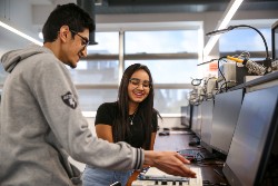 Two students talking by a computer
