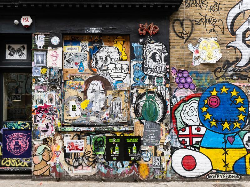 A wall in London's Brick Lane with overlapping posters and street art