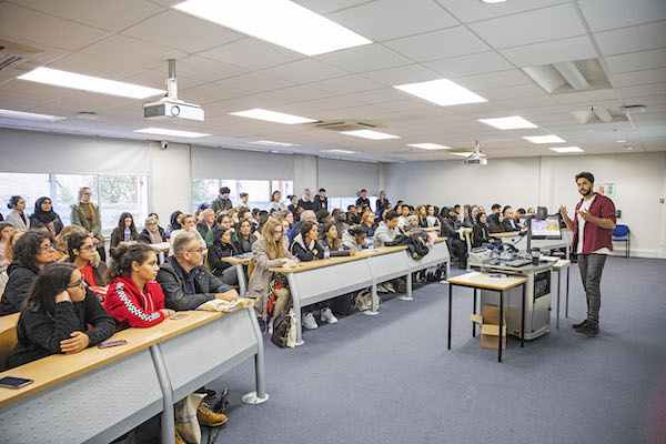 An educator in front of a classroom of students