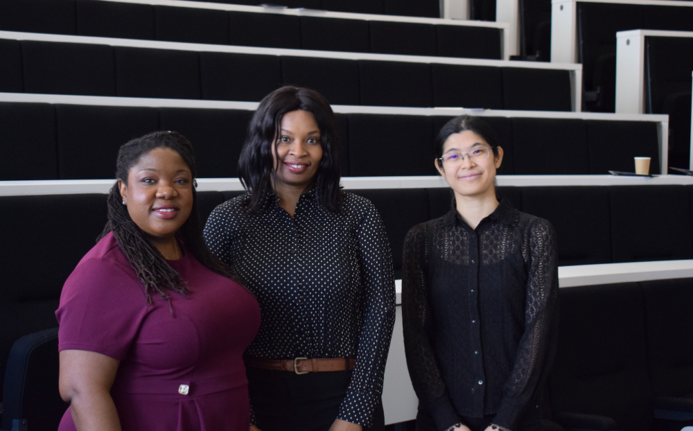 Image of 3 women dressed professionally in a lecture theatre and smiling