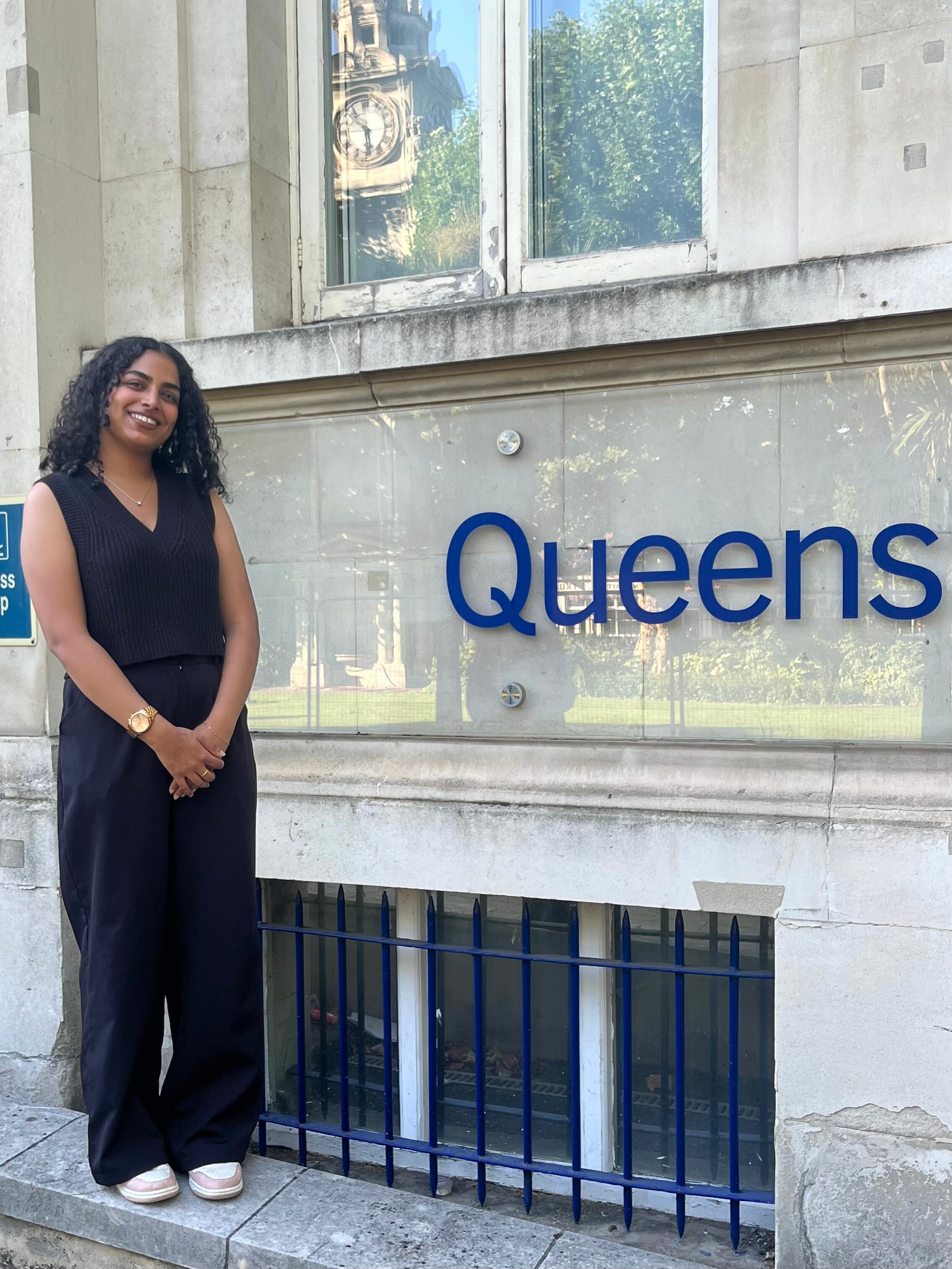 Elvia standing in front of the Queens Building