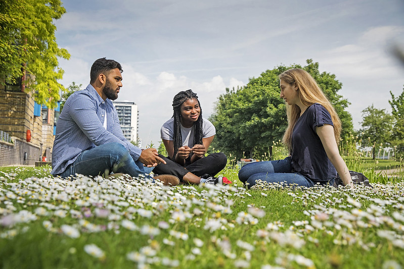 Three students sitting together in a park