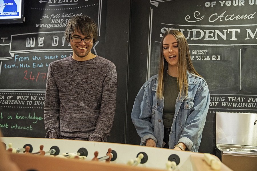 Queen Mary Summer School students playing table football in a campus cafe
