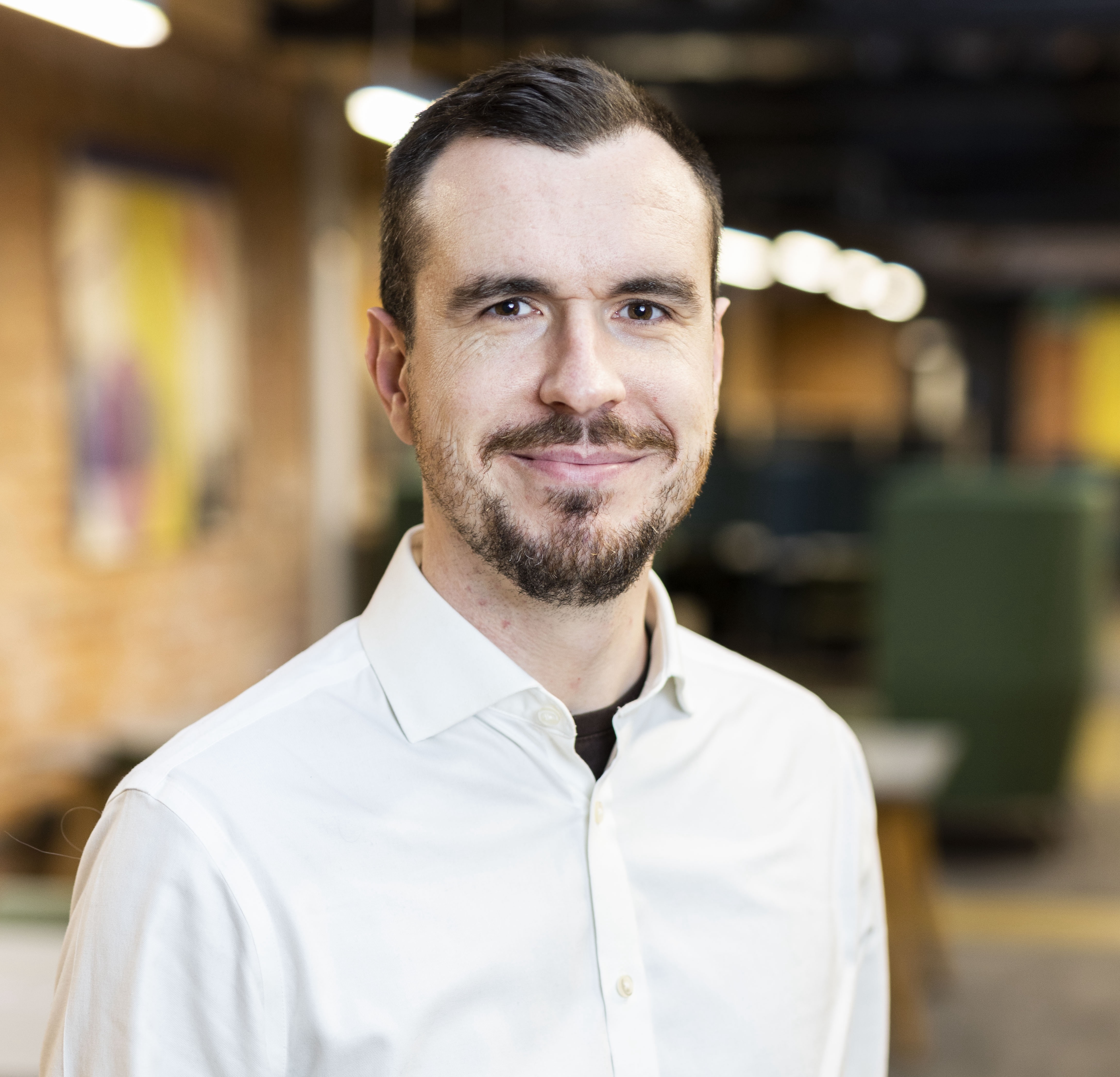 Photo of Jonathan Jackson in a white shirt looking at the camera smiling.